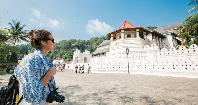 Touriste tenant un appareil photo près d'un temple historique.