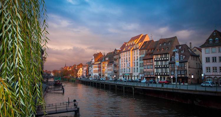 Bâtiments historiques le long d'une rive au coucher du soleil.
