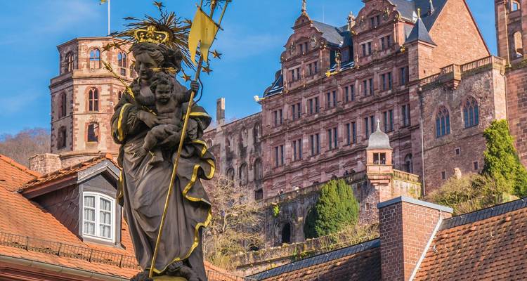 Une statue et une architecture de château historique dans une région montagneuse.