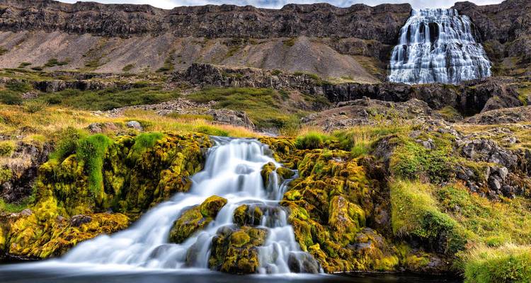 Cascade époustouflante et rochers couverts de mousse dans un paysage pittoresque d'Islande.