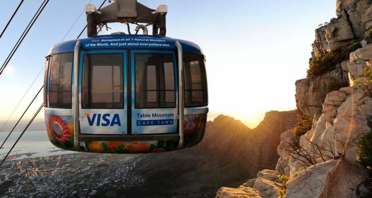 Teleférico ascendiendo con una vista panorámica de montañas y ciudad.