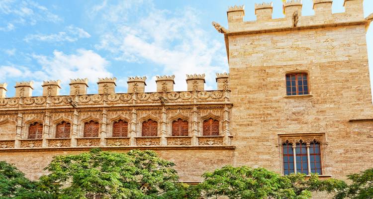 Bâtiment architectural orné avec créneaux et ciel bleu.
