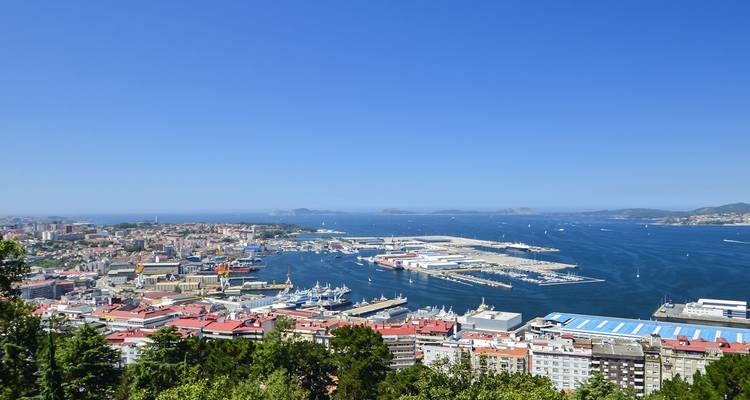 Panorama aérien du port actif de Vigo, de ses quais et de la Ría de Vigo bleu profond sous un ciel d'été dégagé.