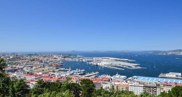 A scenic view of A Coruña city with a coastal harbor and clear skies.