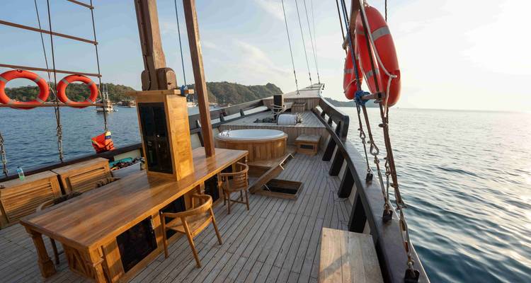 Pont d'un navire en bois avec des sièges et une bouée de sauvetage.