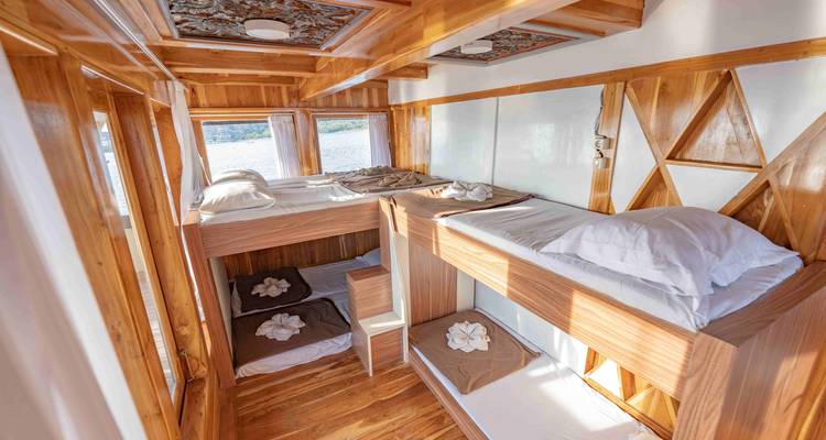 Intérieur d'un navire avec des lits superposés et une décoration en bois.