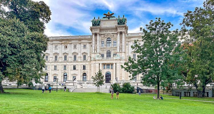 Grand bâtiment historique avec des gens sur la pelouse.