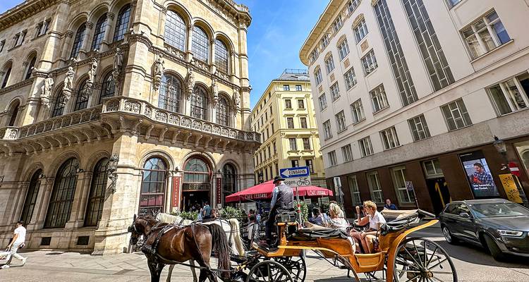 Voiture tirée par des chevaux dans une rue avec des bâtiments historiques.
