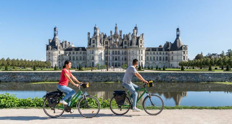 Deux cyclistes devant un grand palais