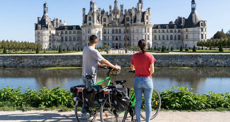 Deux personnes avec des vélos regardant un grand palais