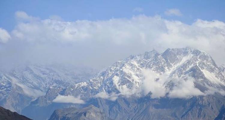 Chaîne de montagnes enneigée sous un ciel bleu dégagé.