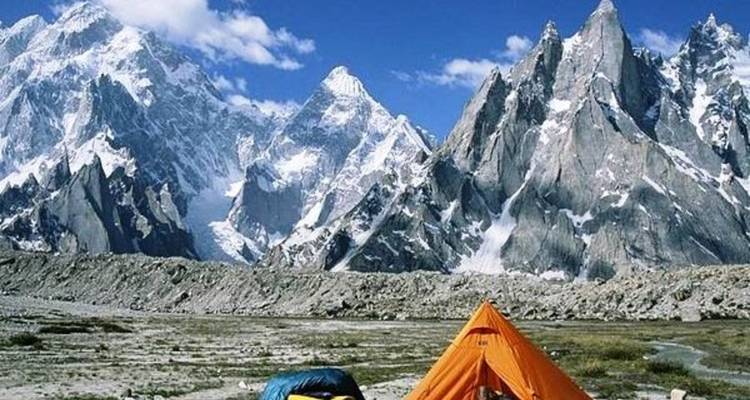 Tentes dans une zone montagneuse avec des pics acérés.