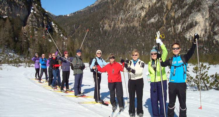 Groupe de skieurs posant ensemble sur une piste enneigée.