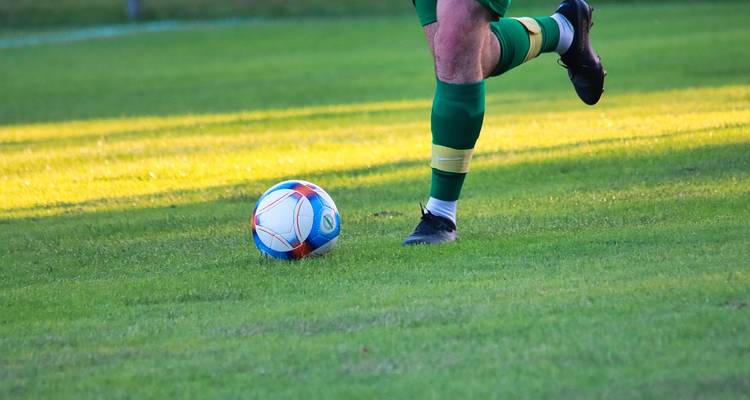 Futbolista en el campo con la pelota.