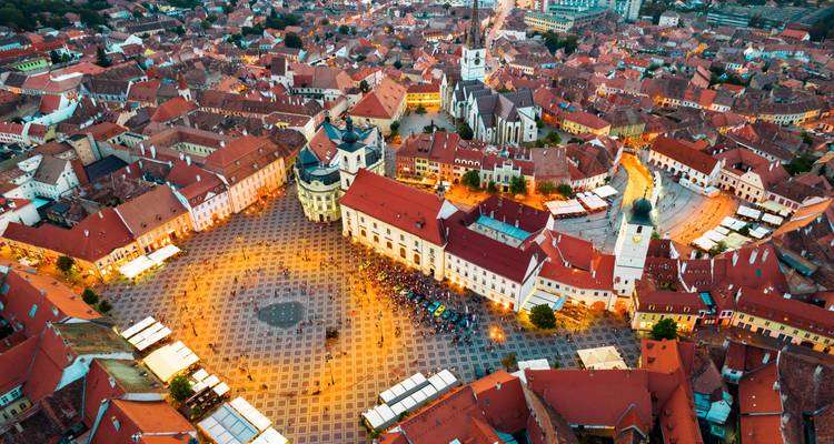 Luftaufnahme einer Stadt mit einem Hauptplatz und roten Dächern