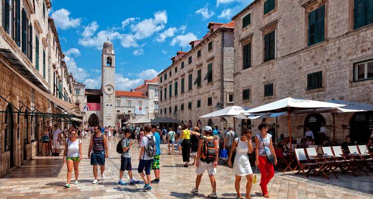 Menschen gehen und sitzen auf einem alten Stadtplatz
