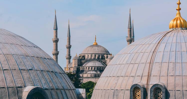Vue d'une mosquée historique avec des dômes et des minarets.