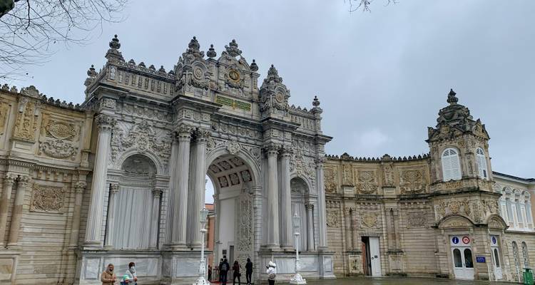 Portail architectural avec des motifs ornés et un petit groupe de personnes.