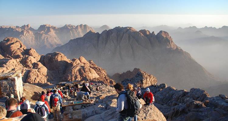Personas caminando por un sendero rocoso de montaña