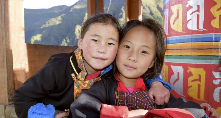 Twee jonge meisjes poseren met kleurrijke traditionele kleding.
