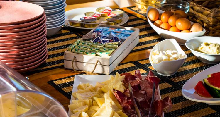 Configuration de nourriture gastronomique avec divers fromages, viandes et tartinades.