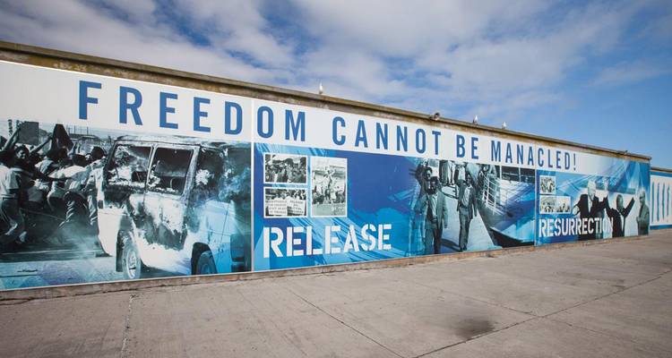Mural histórico en una pared con frases temáticas de libertad.