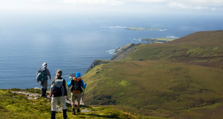 Hikers enjoying a scenic coastal view from a cliff.