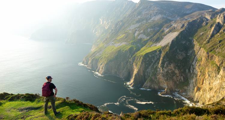 A hiker enjoying a breathtaking view of a rugged coastline.
