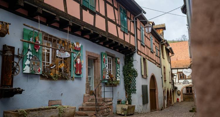 A narrow street with traditional Alsatian houses.