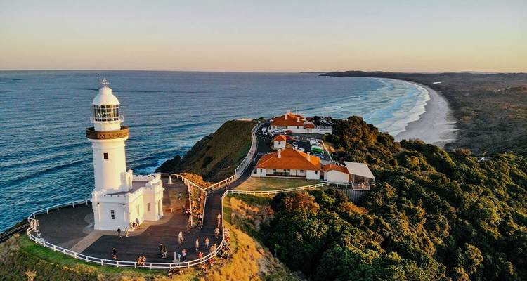 Un phare sur une falaise avec un littoral pittoresque au coucher du soleil.
