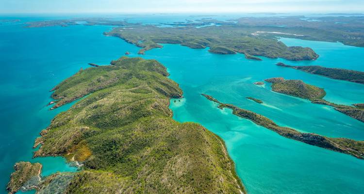 Vue aérienne de mers turquoise parsemées d'îles vertes et escarpées le long de la côte reculée de Kimberley.