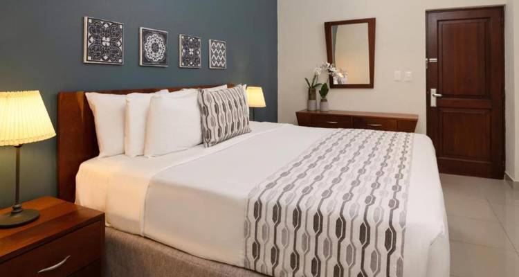 Elegant hotel room with a large bed and soft lamps.