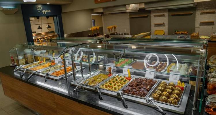 Buffet with a variety of dishes in a well-lit dining space.
