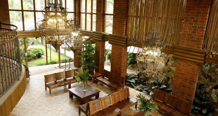Elegant hotel lobby with wooden furnishings and chandeliers.