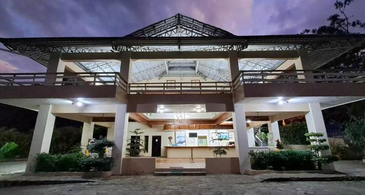 An exterior view of a building at dusk with lights on.