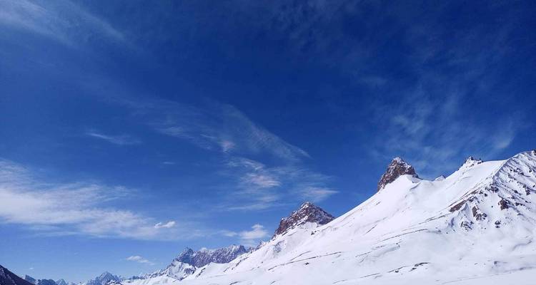 Sommets enneigés sous un ciel bleu dégagé.