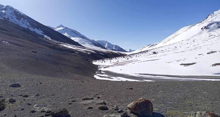 Une vaste vallée avec des montagnes enneigées.