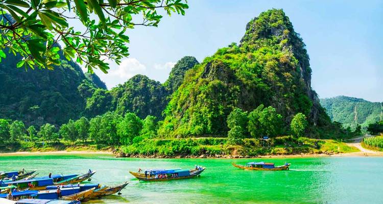 Paysage fluvial serein avec des bateaux et des montagnes verdoyantes luxuriantes.