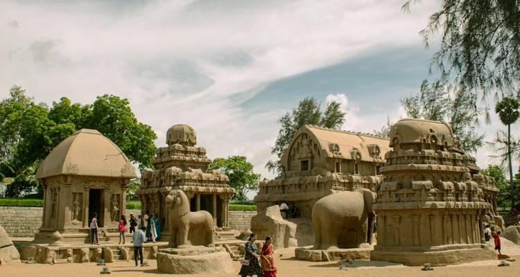 Complejo de templos de piedra antiguos con grandes esculturas y cielos despejados.