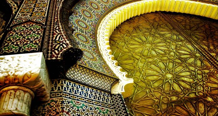 Détails architecturaux marocains complexes avec arches et carreaux de mosaïque.