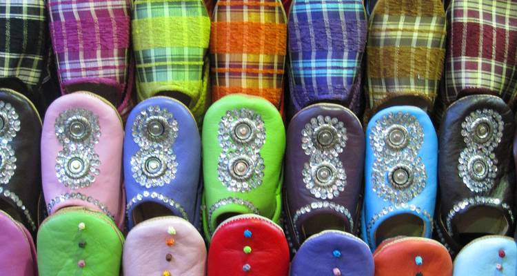 Chaussures marocaines traditionnelles et colorées exposées.
