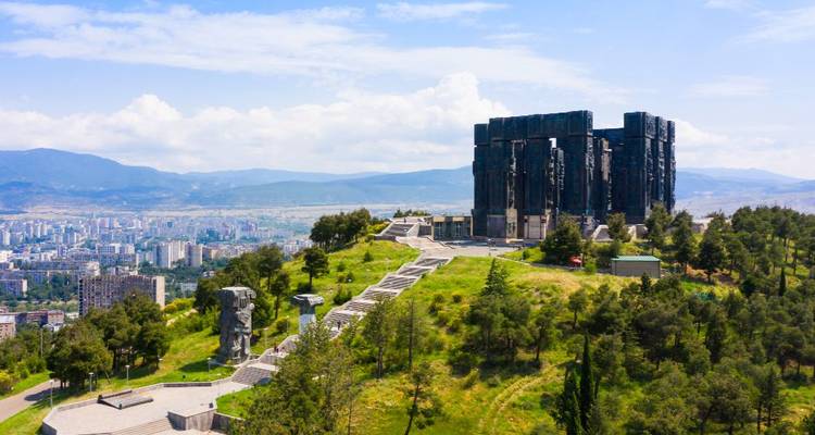 A grand monument with cityscape views in the background.