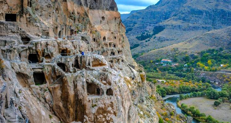 A cliffside ancient cave city with scenic valley views.