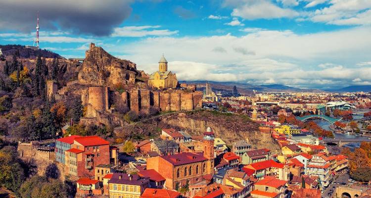 Aerial view of a historical city with a fortress and traditional architecture.