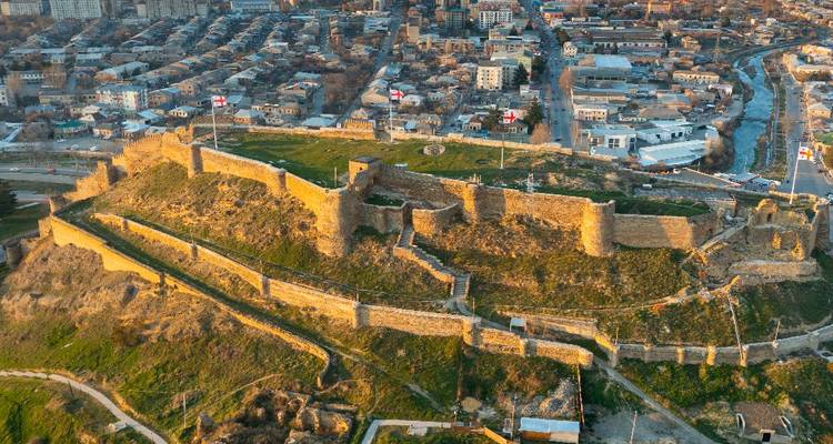 A historical fortress situated on a hill overlooking a city.