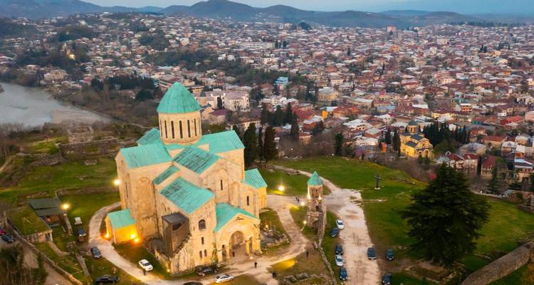 A church with a turquoise roof overlooking a city.