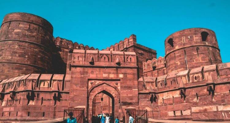 Fort en grès rouge avec créneaux contre un ciel dégagé.