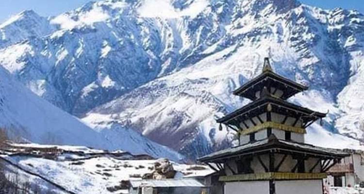 Vista panorámica de un templo con montañas cubiertas de nieve al fondo.