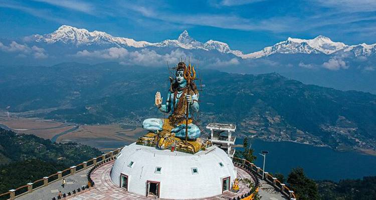 Gran estatua con una cordillera en el fondo.