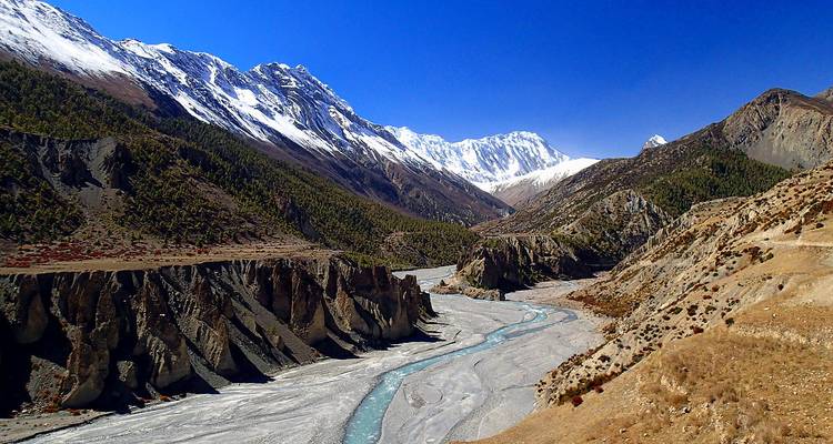 Vue panoramique des montagnes enneigées avec une rivière serpentine à Manang.